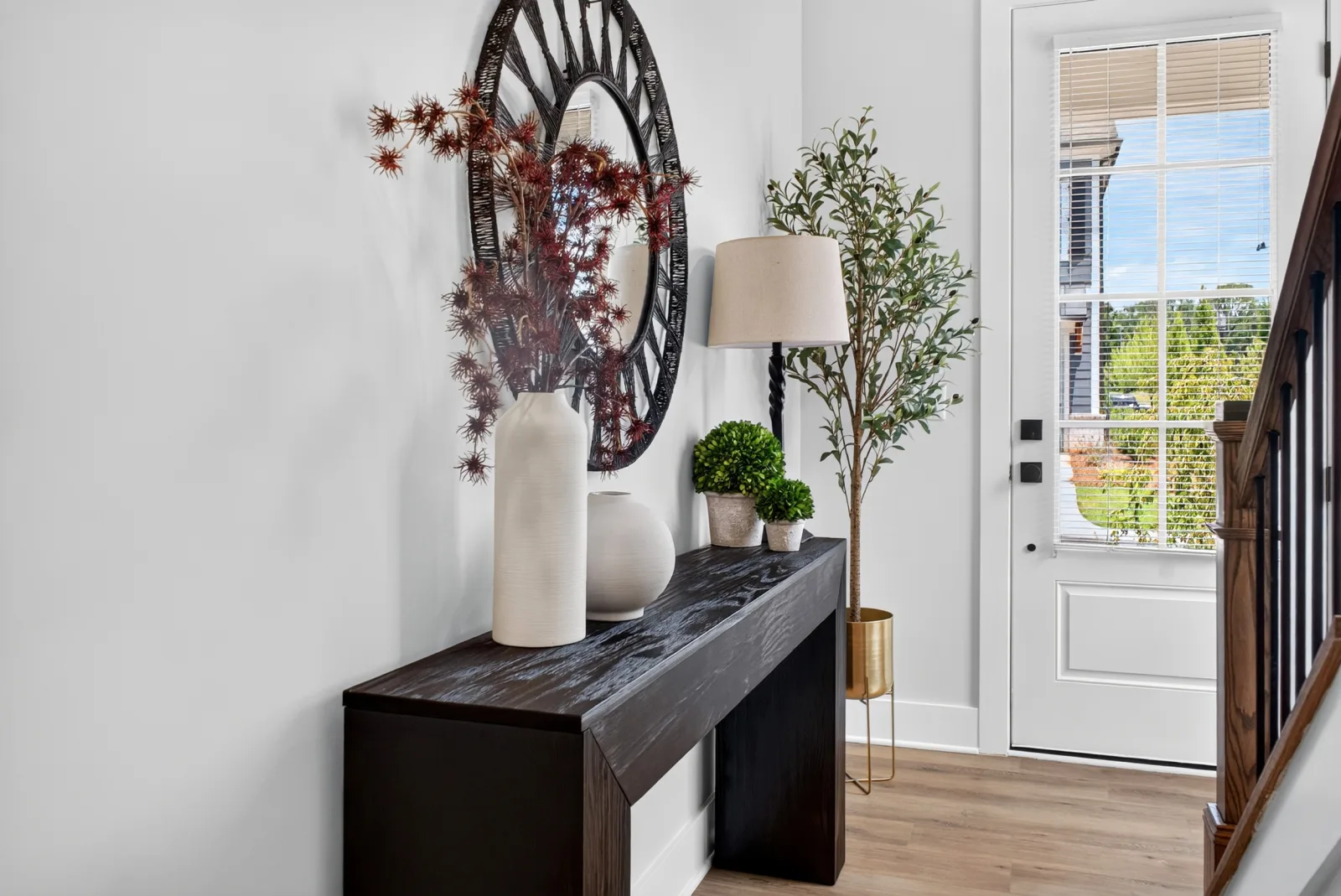 Staged foyer with console and olive tree