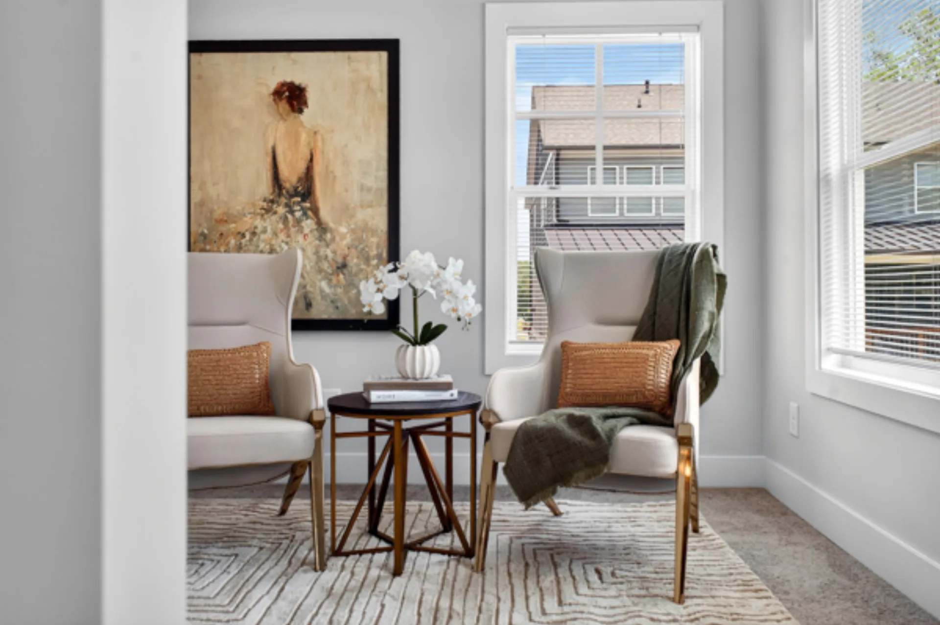 Staged sitting area with cream wingback chairs