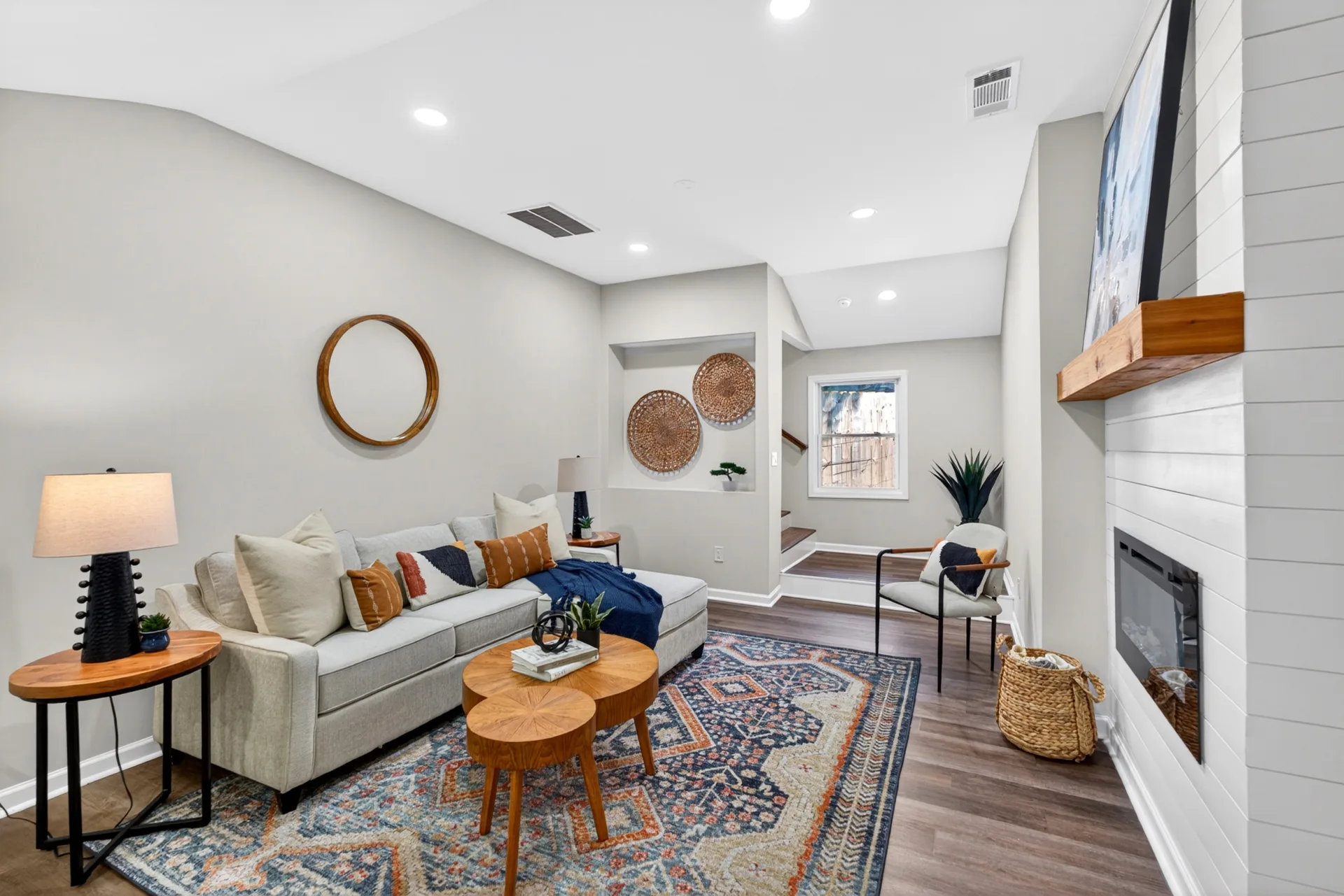 Staged family room with shiplap fireplace and blue rug