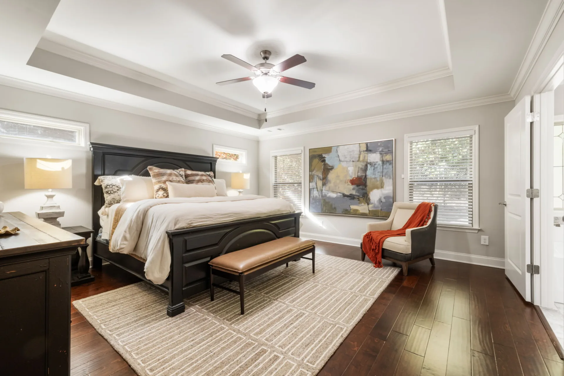 Staged primary bedroom with warm patterned accents